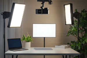 A modern influencer workspace for filming unboxing videos, with a neat white table, LED panel lights, a mounted overhead camera, a laptop nearby